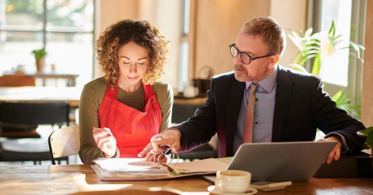 Small business owner reviewing documents with an attorney.